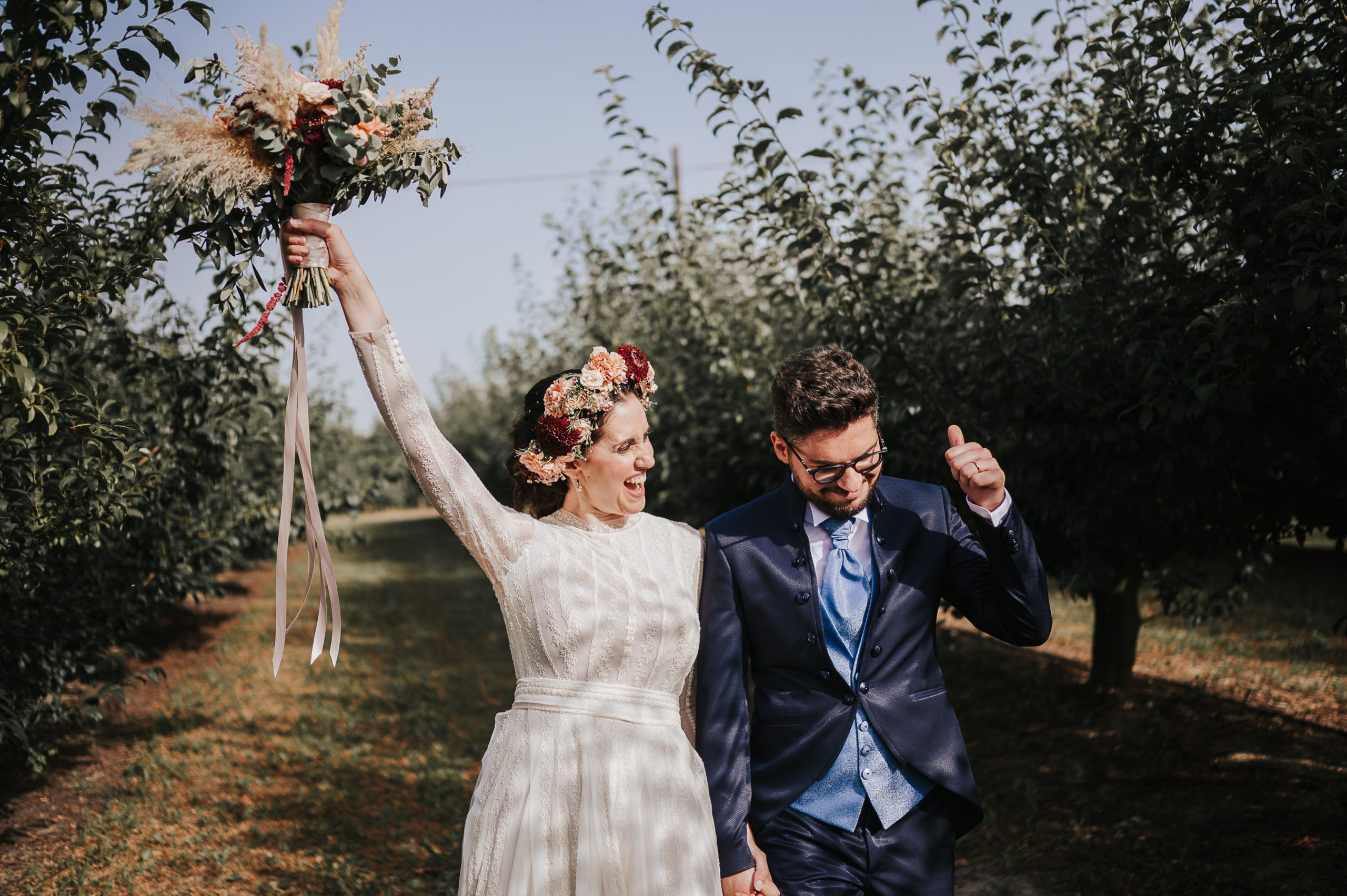 Contact us theme Picture. A Wedding Couple walking happy among trees after the wedding ceremony in Italy